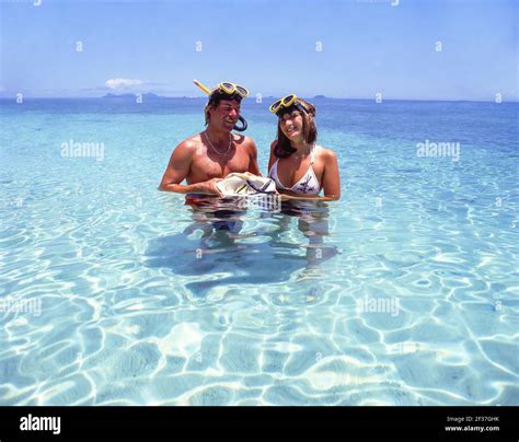 Couple with snorkeling gear in sea, Beachcomber Island Resort ...