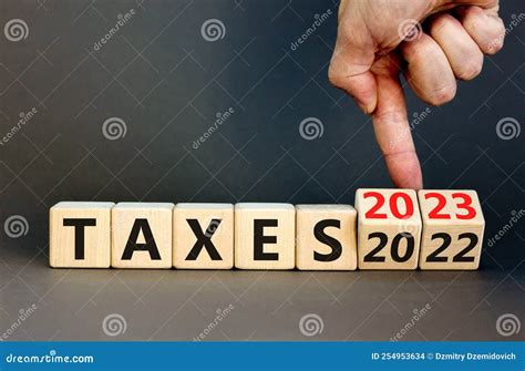 2023 Taxes New Year Symbol. Businessman Turns a Wooden Cube and Changes ...