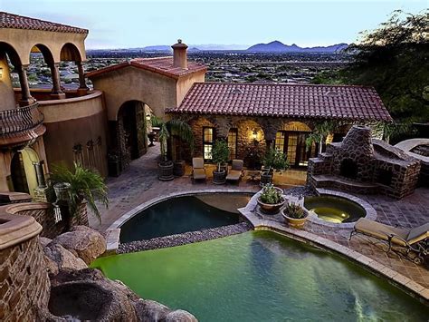 Hillside Spanish style home - Waterfalls from under the home pour into the pool, which steps ...