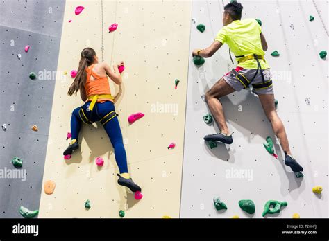 Sporty people climbing wall Stock Photo - Alamy