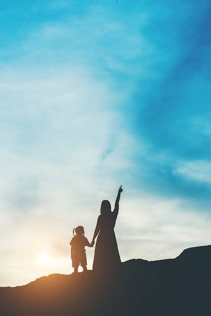 Free Photo | Silhouette of mother with her daughter standing and sunset