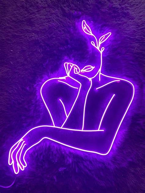 a purple neon sign with a woman's face and hands on her chest, in the ...