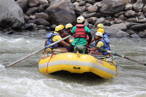 a group of people riding on the back of a raft down a river