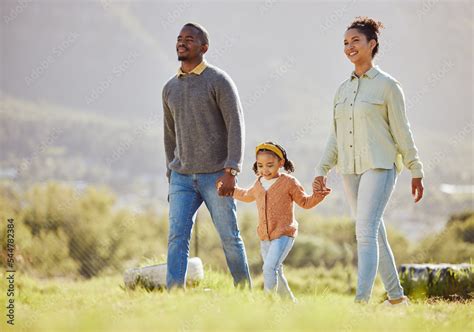 Happy family, walking and relax at a park with girl and parents, holding hands and enjoy their ...