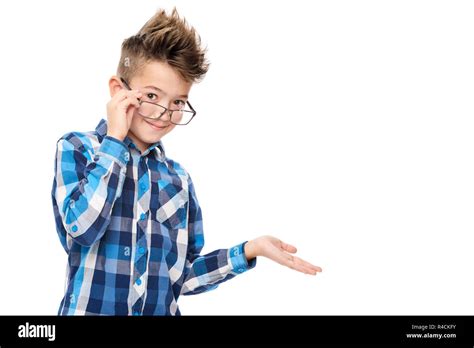 Cute smiling boy wearing reading glasses and pointing with hand to one side studio portrait on ...