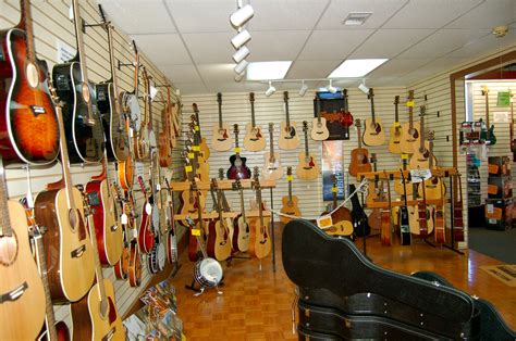 guitars are lined up on the wall in this music store, and there is also a guitar case