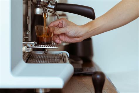 Crop barista making coffee in coffeemaker · Free Stock Photo