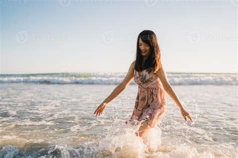 Young Asian woman walking on beach. Beautiful female happy relax ...