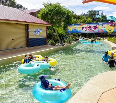 people are floating on inflatable rafts at the water park