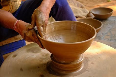 Premium Photo | Pottery - skilled wet hands of potter shaping the clay on potter wheel