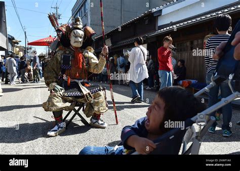 A child (R,below) looks at a man acting Chinzei Hachiro Tametomo (Minamoto no Tametomo,L), a ...