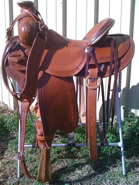 a saddled horse is standing in the grass