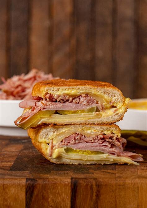 Cuban Sandwich is a classic hot pressed sandwich with pulled pork, sliced ham, and melted Swiss ...