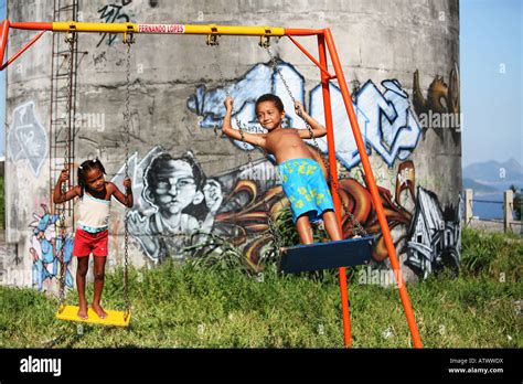 Children play on swing in Rio de Janeiro favela slum with graffiti ...