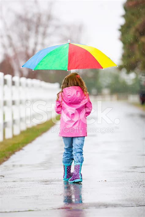 Young Girl Walking In Rain With Rainbow Umbrella Stock Photo | Royalty ...