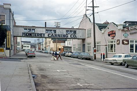 two people walking down the street under an old sign that reads, henry ...