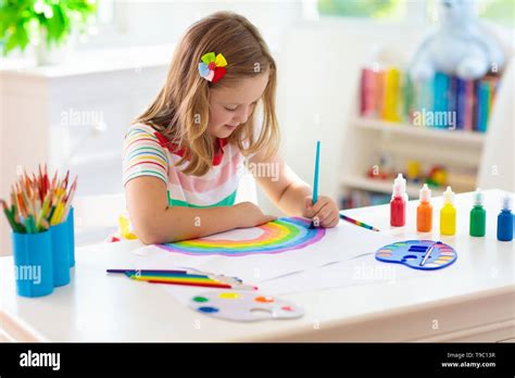 Kids paint. Child painting in white sunny study room. Little girl ...