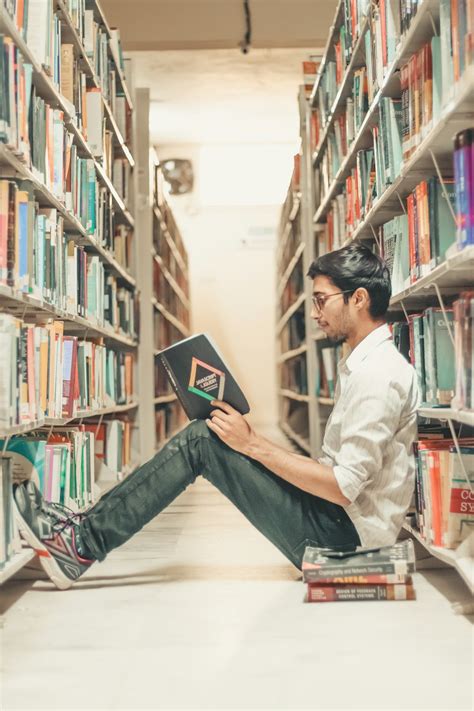 Man reading book on the library photo – Free Young student Image on ...