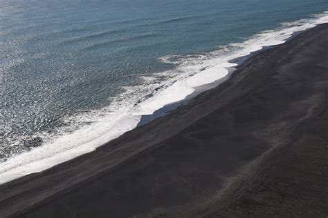 An aerial view of a black sand beach photo – Free Vik Image on Unsplash