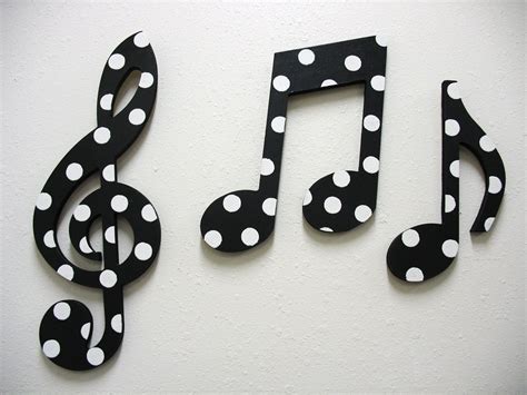 a black and white musical note with polka dots on it's sides is mounted to the wall
