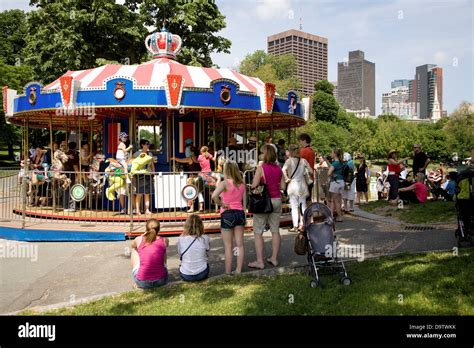 Parents watch children ride the Frog Pond Merry-Go-Round in the Boston Common Park on Memorial ...