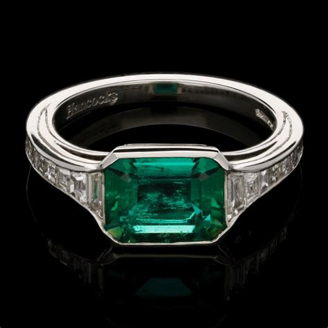 An elegant Colombian emerald ring set in platinum with calibre step-cut ...