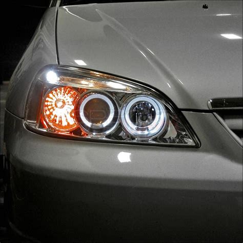 the front end of a silver car with orange lights on it's headlight