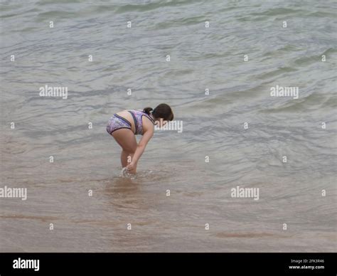 Little girl in swimsuit bathing on the shore of the beach Stock Photo - Alamy