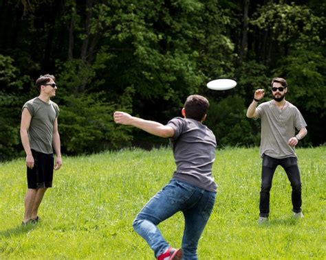 Free Photo | Adult male throwing frisbee for friend in park