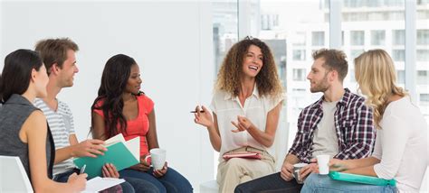 Smiling therapist speaking to a rehab group at therapy session | Berkshire Psychiatric