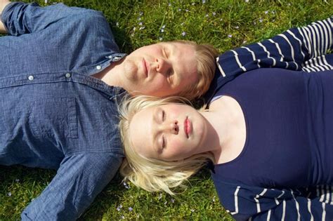 Premium Photo | Young couple laying on grass side by side