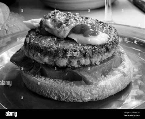 Tasty beef burger with cheese, ketchup and mustard. Gourmet food in black and white Stock Photo ...