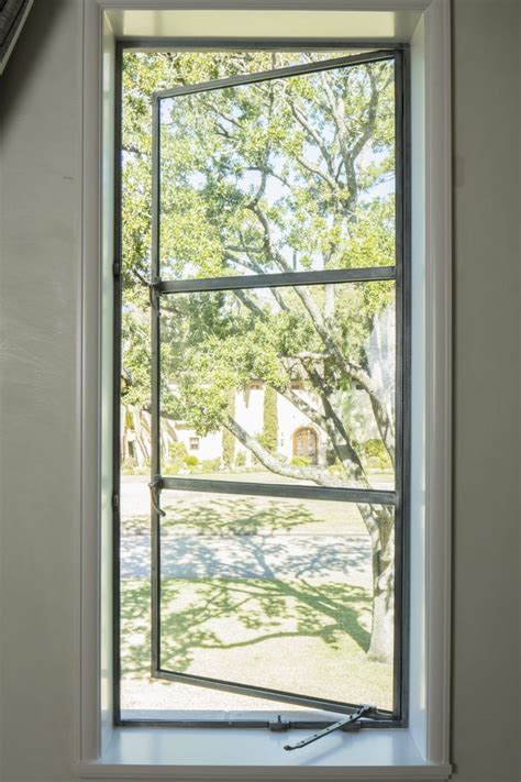 an open window with the view of a tree outside in front of it on a ...