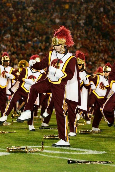 a marching band performing on the field at a football game in maroon ...