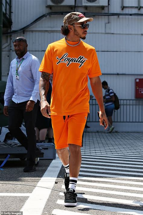 Lewis Hamilton catches the eye in a bold orange slogan T-shirt ...