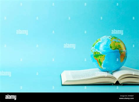 Earth globe on an open book on a blue banner background. Knowledge ...