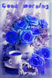 blue roses are in a vase with a cup and saucer