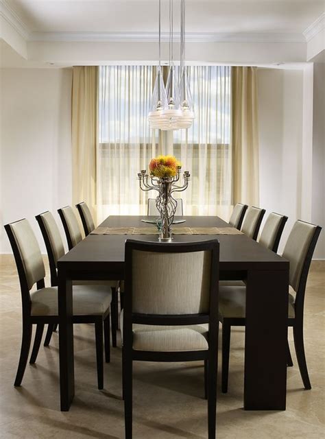 a dining room table with chairs and a vase filled with flowers