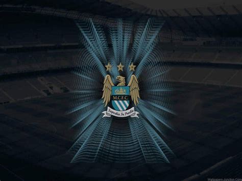 Download Manchester City FC Logo Over Shaded Stadium Wallpaper | Wallpapers.com