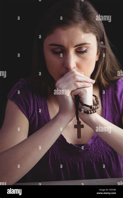 Woman praying with wooden rosary beads Stock Photo - Alamy