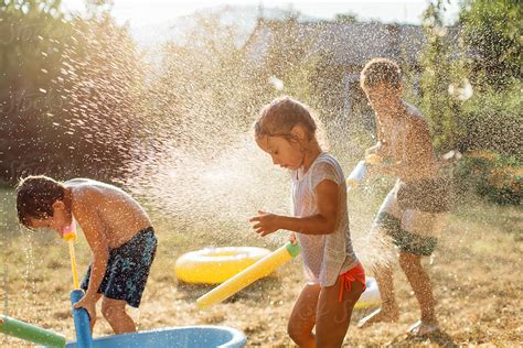 "Children Playing With Water Outdoors" by Stocksy Contributor "Dejan ...