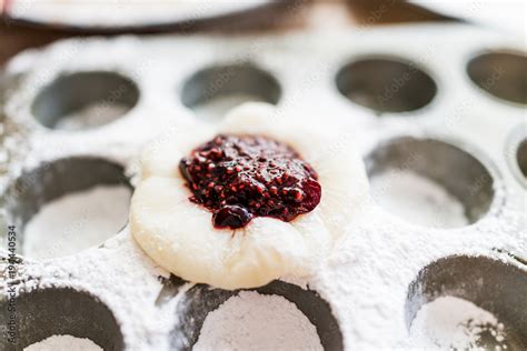 Piece of mochi sticky glutinous rice cake dusted with starch flour to make dessert in muffin pan ...