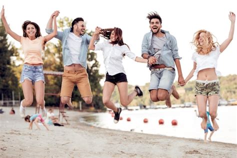 Premium Photo | Group of happy young people jumping on the beach