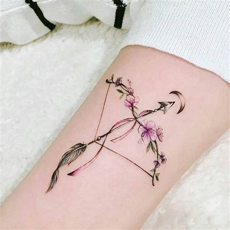 Small floral bow and arrow tattoo pointing to a crescent moon inked on ...