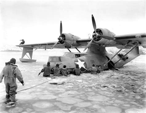 US Navy personnel freeing a PBY-5A Catalina aircraft from frozen waters ...