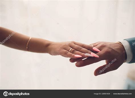 Newlyweds holding hands, their weddingbands showing.White background ...