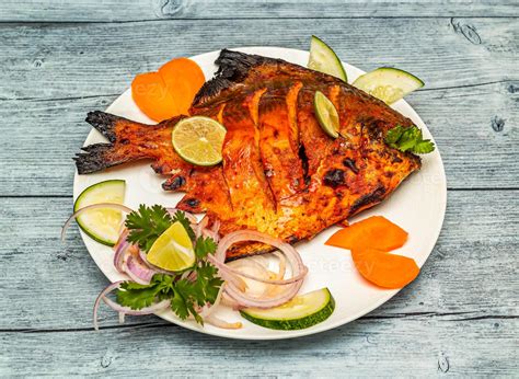 tandoori japuta pescado freír con limón y cebolla servido en plato aislado en de madera mesa ...