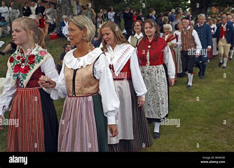 Couples in traditional Swedish folk costumes parade at midsummer celebration. Naas castle estate ...