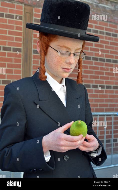 Orthodox religious Jewish boy with red hair & sidelocks examines an ...