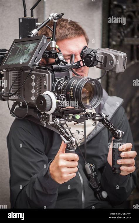 Behind the scene. Cameraman shooting the film scene with his camera on outdoor set. Photography ...